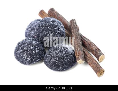 Many tasty candies and dried sticks of liquorice root isolated on white Stock Photo