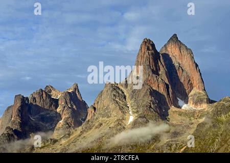 the steep, glaciated granite peaks of the western side of the prince christian sound and wisps of fog, in southern greenland, from a cruise ship Stock Photo
