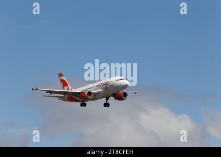 Air Canada Rouge Airbus A319  descends to land at the Montréal-Pierre Elliott Trudeau International Airport. Montreal,Quebec,Canada Stock Photo