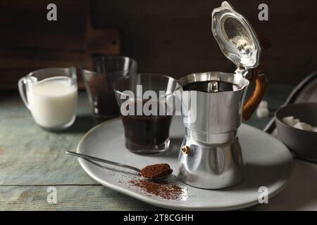 Brewed coffee in moka pot and glass on rustic wooden table Stock Photo