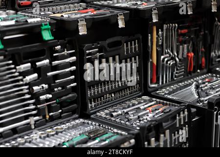 Plastic boxes with mechanic tool sets on showcase in tool store. Selective focus. Stock Photo