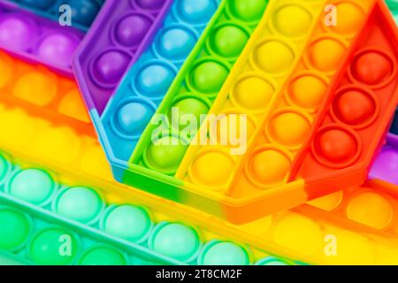 Pop it antistress close-up. Modern antistress toy. Background from rainbow toys. Stock Photo