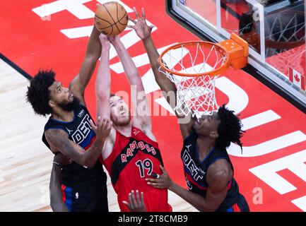 Toronto, Canada. 19th Nov, 2023. Jakob Poeltl (C) of Toronto Raptors fights for a rebound with Marvin Bagley III (L) and James Wiseman of Detroit Pistons during the 2023-2024 NBA game between Toronto Raptors and Detroit Pistons in Toronto, Canada, on Nov. 19, 2023. Credit: Zou Zheng/Xinhua/Alamy Live News Stock Photo