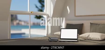 A laptop mockup on the bed in the cozy minimalist bedroom with large window. 3d rendering, 3d illustration Stock Photo