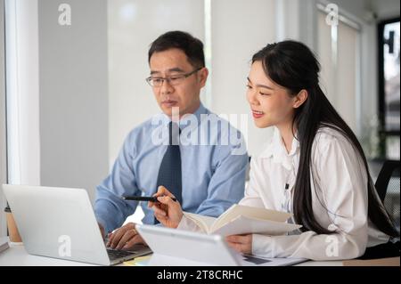 Young motivated businesswoman working with experience senior businessman in the white modern office room. Businesspeople concept. Stock Photo