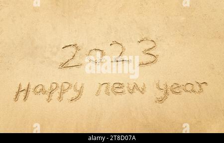 2023 happy new year handwritten in sand on a beautiful beach Stock Photo