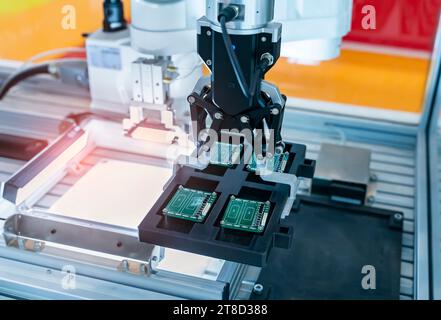 automatic robot for print circuit board (PCB)assembly machine during soldering or welding part at factory Stock Photo