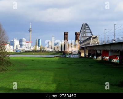 Blick auf die Eisenbahnbruecke Duesseldorf Neuss mit Resten des historischen Brueckenkopfes, im HIntergrund der Rheinstrom mit der Skyline der Landeshauptstadt Eisenbahnbruecke Neuss Duesseldorf histor. Brueckenkopf *** View of the Duesseldorf Neuss railroad bridge with remains of the historic bridgehead, in the background the Rhine river with the skyline of the state capital Neuss Duesseldorf railroad bridge historic bridgehead Credit: Imago/Alamy Live News Stock Photo