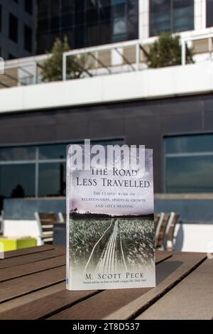 Close-up M. Scott Peck's The Road Less Traveled book on a wooden table. Stock Photo