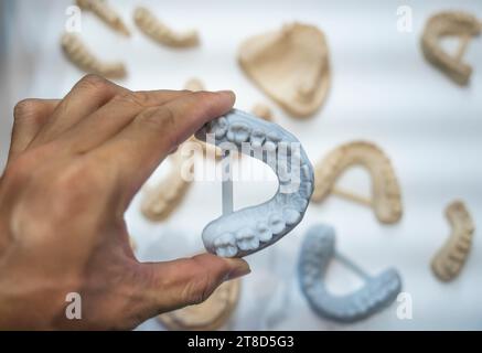 Dental technician modeling frame for implant production from a 3d printer at the laboratory Stock Photo
