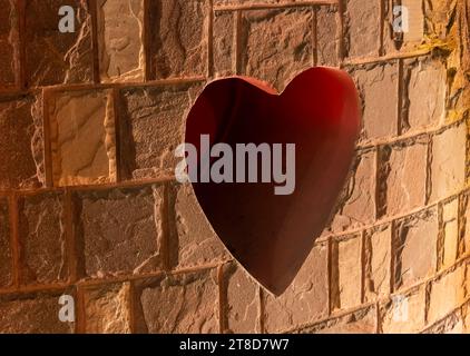 Heart shaped hole in old brick wall Stock Photo