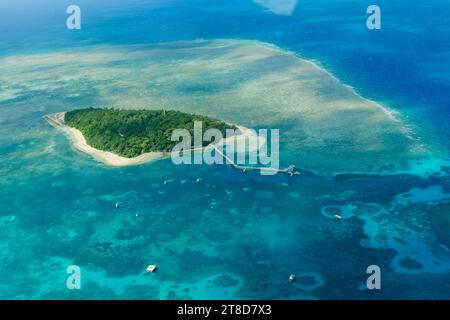 An aerial view of the coral reefs and clear turquoise waters surrounding Green Island, a small tropical isle in the outer Great Barrier Reef Stock Photo
