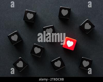 Finding a match in social media. To find love. Online love or matching in dating apps. Heart symbols on black cubes Stock Photo