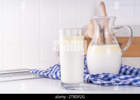 Non-Homogenized, whole milk, cream-top layered dairy product, Creamline Milk concept. Organic farm natural, unpasteurized milk in glass and jug, on wh Stock Photo