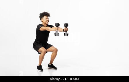 athlete man performing squats holding dumbbells weights on white background Stock Photo