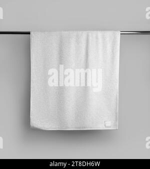 Mockup of a terry white towel with a label on a metal bar, hanging towelling for design, branding. Product photography. Home decor for the bath. Templ Stock Photo