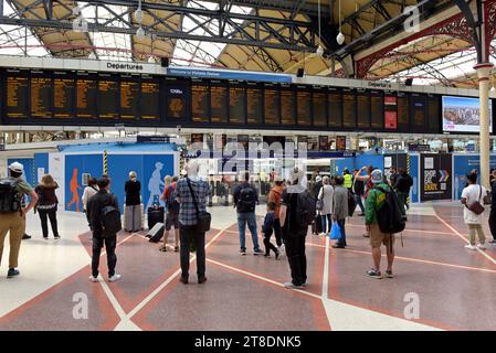 People waiting for trains watching the departure board at Victoria Railway Station, London, August 2023 Stock Photo