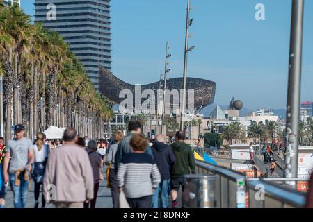 Barcelona, Spain: November 19, 2023: People Wal k Barceloneta Beach with Frank Gehry's Peix d'Or (Whale Sculpture) in winter 2023. Stock Photo