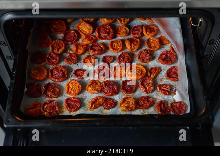 Trays of fresh cherry tomatoes on racks drying in the oven Stock Photo