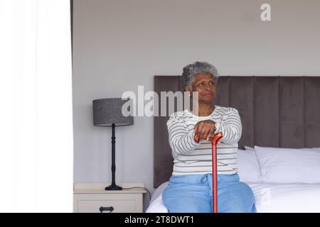 Serious senior african american woman talking on bed Stock Photo