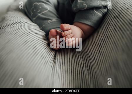 Close up of baby's feet and toes laying on gray neutral blanket Stock Photo