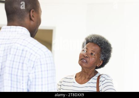 African american male doctor talking with senior woman in hospital reception Stock Photo