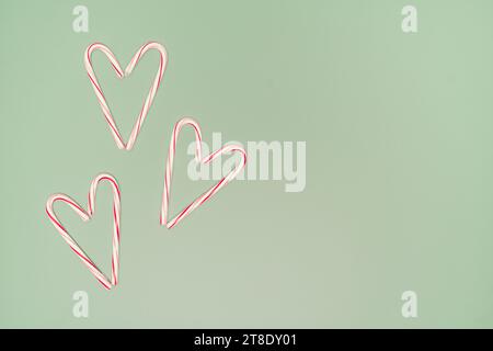 Three Candy Cane Hearts On a Green Background With Copy on the Right Stock Photo