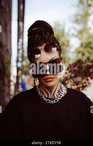 Beautiful young woman with a tattoo on her neck and dreadlocks. Stock Photo