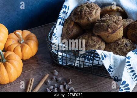 Muffins, pumpkins, cinnamon, and chocolate chips on wooden counter. Stock Photo