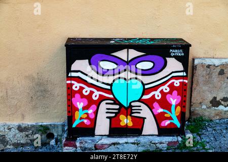Vividly painted electrical junction box brightens Lisbon's streets, adding a pop of color amidst its charming urban landscape Stock Photo