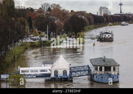 Cologne, Germany. 20th Nov, 2023. Parts of the riverbank are flooded. The wave will subside towards the end of the week, said a spokesman for the Rhine Waterways and Shipping Office in Duisburg on Monday. High water mark one, which comes into effect at a level of 6.20 meters, has been in force in Cologne since Saturday. Ships must navigate the Rhine in the middle of the river and at a reduced speed. (To dpa/lnw: 'Benches in the water and slow ships: high water near Cologne') Credit: Oliver Berg/dpa/Alamy Live News Stock Photo