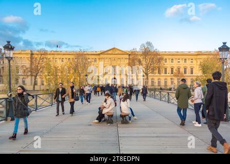 Paris, France, A landcape with tourists walking on Passerelle des Arts to Louvre museum, Editorial only. Stock Photo