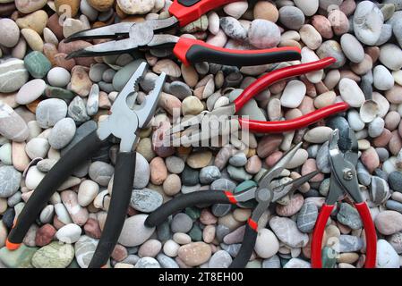 Concept Photo With Set Of Different Types Of Mechanics Pliers On Smooth Rocks Top View Stock Photo