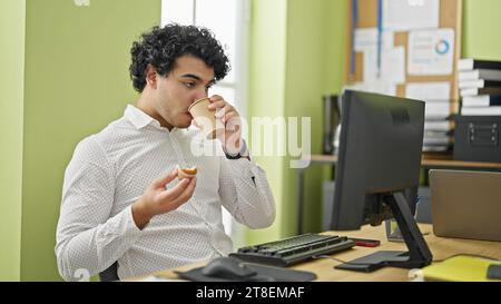 Young latin man business worker having breakfast at office Stock Photo