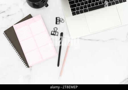 Modern white office desk table with laptop computer, stationery and notepads and cup of coffee. Top view. Copy space, flat lay. Stock Photo
