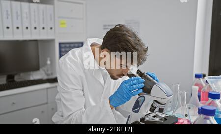 Young arab man scientist using microscope at laboratory Stock Photo
