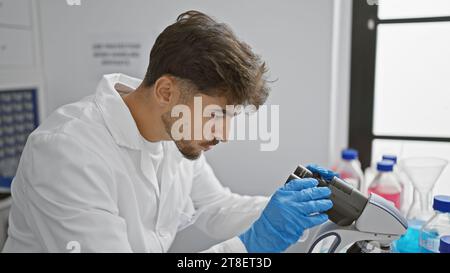 Young arab man scientist using microscope at laboratory Stock Photo
