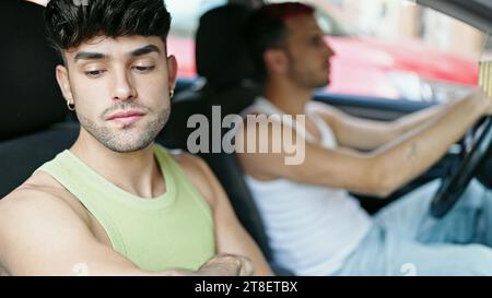 Two men couple driving car arguing at street Stock Photo