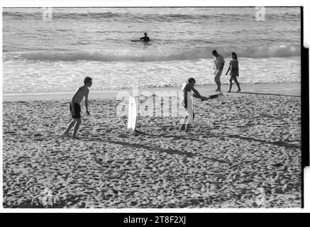 Teenagers play cricket on the beautiful sandy beach at Gwynver Beach at Sennen with a surf board as the stumps in Cornwall, England, August 2000. Picture: ROB WATKINS Stock Photo