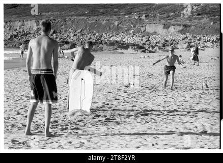 Teenagers play cricket on the beautiful sandy beach at Gwynver Beach at Sennen with a surf board as the stumps in Cornwall, England, August 2000. Picture: ROB WATKINS Stock Photo