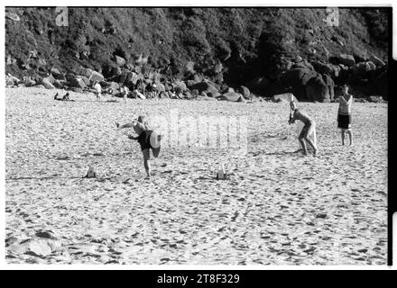 Teenagers play cricket on the beautiful sandy beach at Gwynver Beach at Sennen with a surf board as the stumps in Cornwall, England, August 2000. Picture: ROB WATKINS Stock Photo