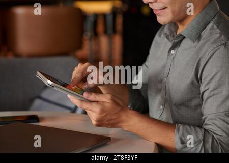 Cropped image of smiling young businessman using application on smartphone when planning work Stock Photo