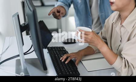 Two developer programmer discussing to checking code on monitor about programming to developing web. Stock Photo