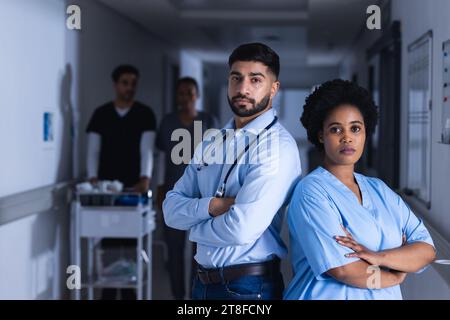Portrait of diverse male and female doctors in hospital corridor Stock Photo