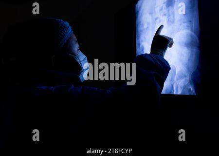 Asian female doctor with face mask looking at x-ray in hospital Stock Photo