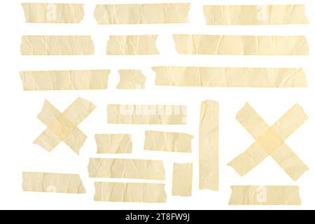 This photo features an array of masking tape and adhesive strips arranged on a plain white background. Various lengths of beige colored duct tape are Stock Photo