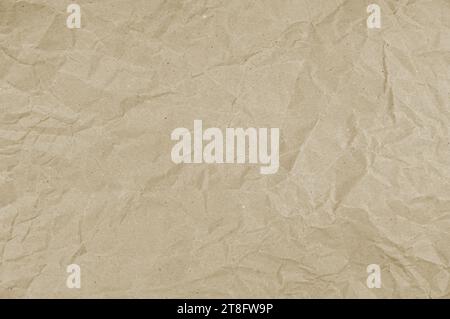 Tactile texture of crumpled beige paper. Wrinkled wrapping paper background. Packaging paper. Stock Photo