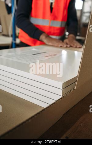 A man packs furniture products in cardboard packaging. Furniture manufacturing Stock Photo