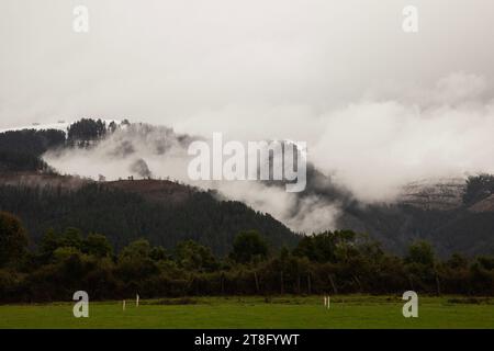 Landscape of a countryside on a cold day with mist rising from the mountains Stock Photo
