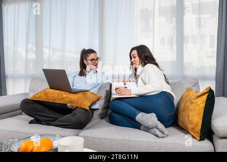Two young colleagues college students of faculty of law, future lawyers study together as roommates preparing for educational exam using laptop comput Stock Photo